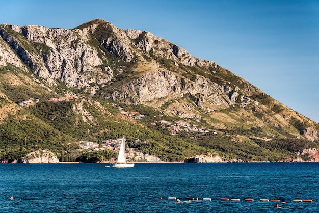 Sailboat floating on the Adriatic Sea in Montenegro Saint Setafan Island in the background