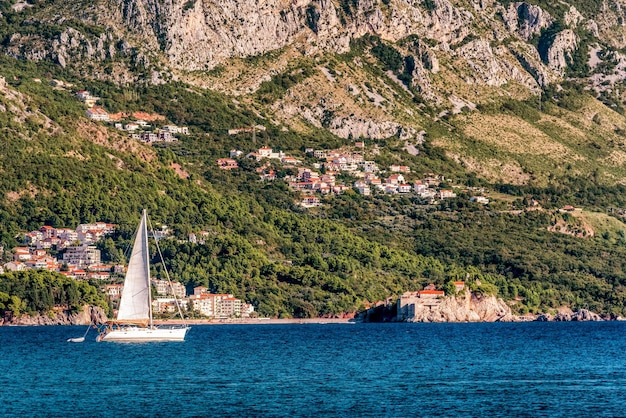 Sailboat floating on the Adriatic Sea in Montenegro Saint Setafan Island in the background