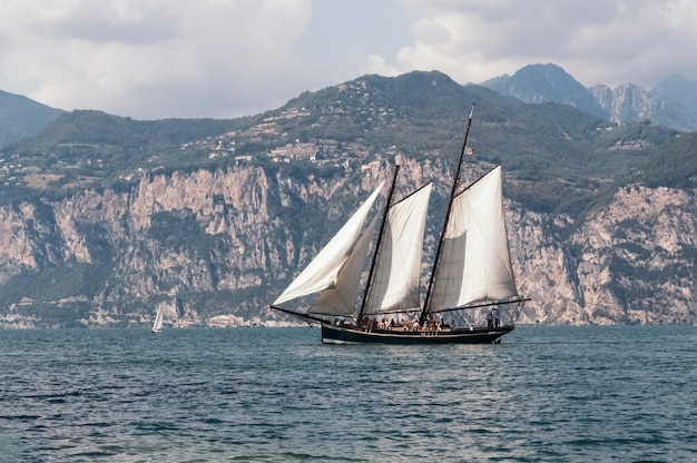 Sailboat floats on the background of a mountain range