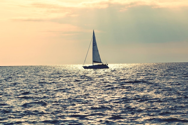 写真 夕暮れの海での帆船