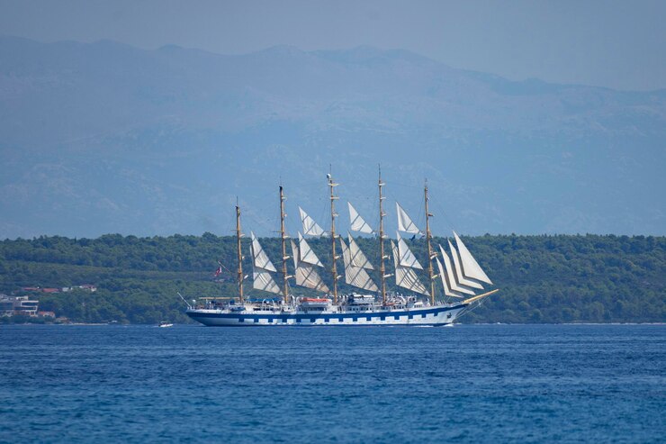 Photo a sailboat is sailing in the water with a mountain in the background
