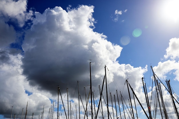 雲 に 対し て の 帆船 の マスト - 雲 の 景色 と 共 に 晴れた 日