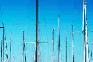 Photo sailboat masts in harbor against blue sky