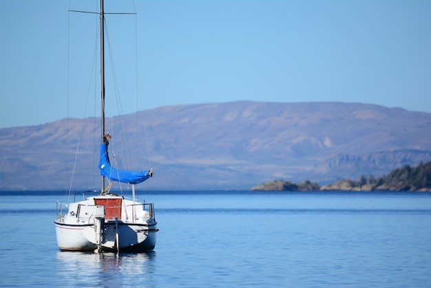 sailboat in the middle of the lake panoramic landscape of mountains and lake