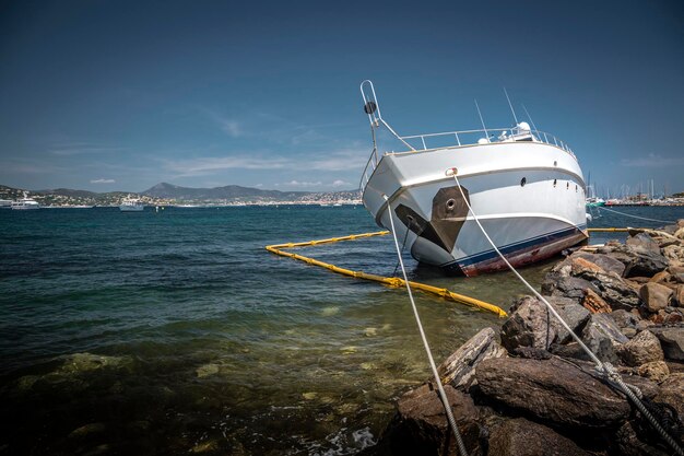 Sailboat moored on sea shore against sky