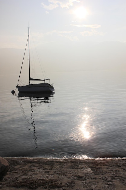 Фото Парусная лодка на море на фоне неба во время захода солнца