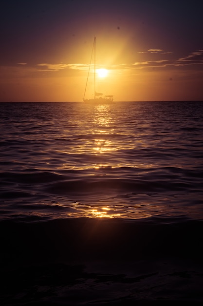 Sailboat sailing on the horizon during sunset