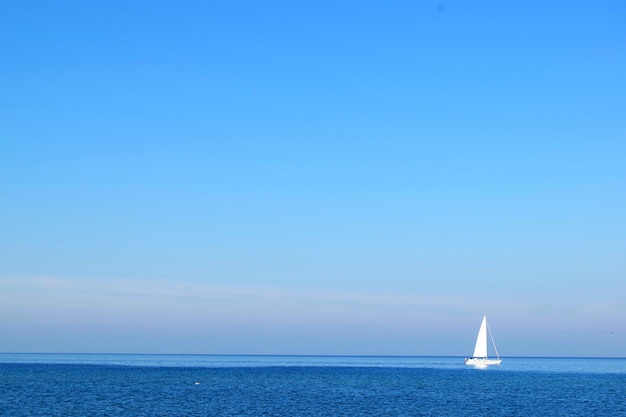 写真 青い空を背景に海を航海する帆船