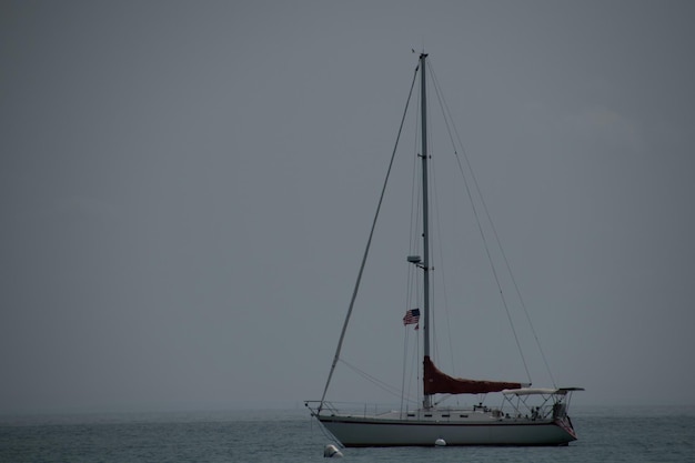 Фото Парусная лодка плывет по морю напротив неба