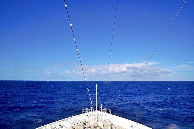 Sailboat sailing in sea against blue sky