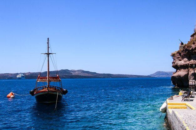 Sailboat sailing on sea against clear blue sky