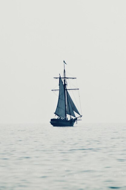 Photo sailboat sailing on sea against clear sky