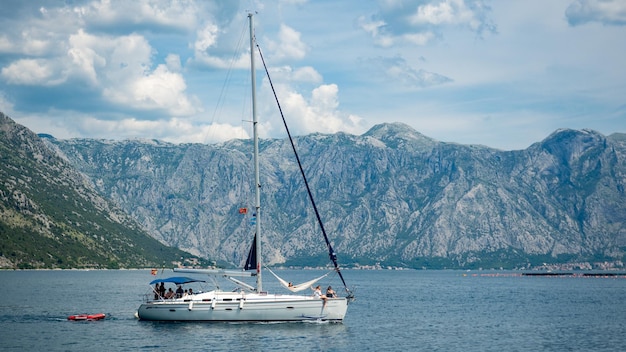 Sailboat sailing on sea against mountains