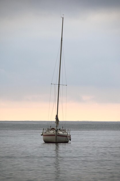 Foto barca a vela che naviga sul mare contro il cielo durante il tramonto