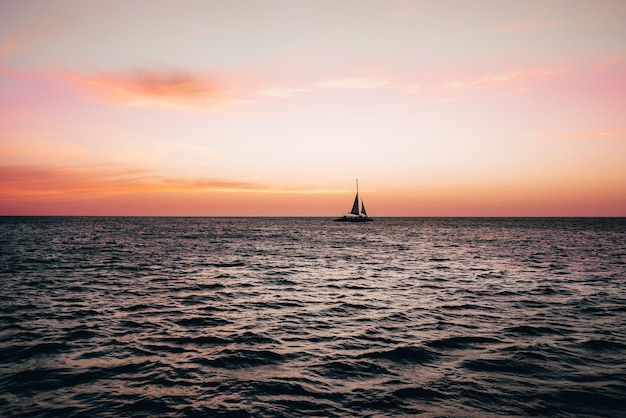 sailboat sailing on sea against sky during sunset