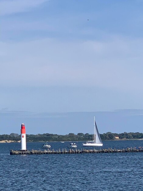 Sailboat sailing on sea against sky