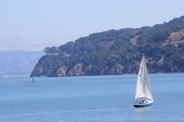 山から海を航海する帆船