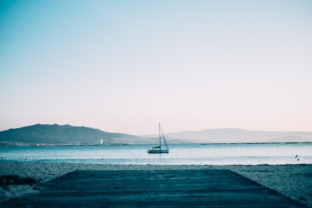 Foto barca a vela che naviga in mare al tramonto