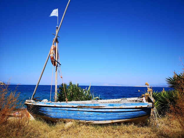 Sailboat in sea against clear blue sky