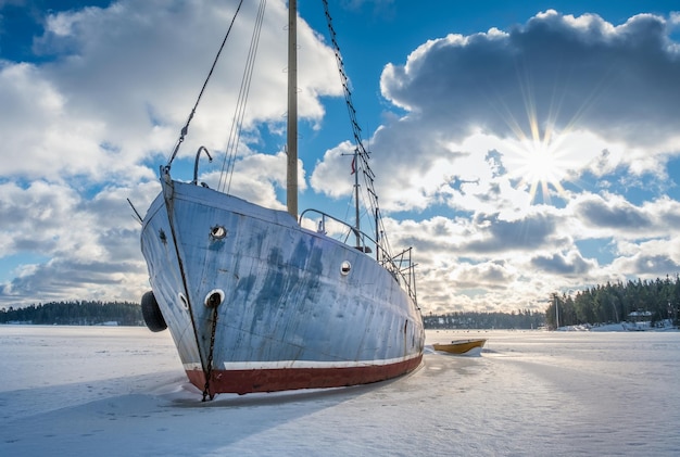 Foto barca a vela sulla riva coperta di neve contro il cielo