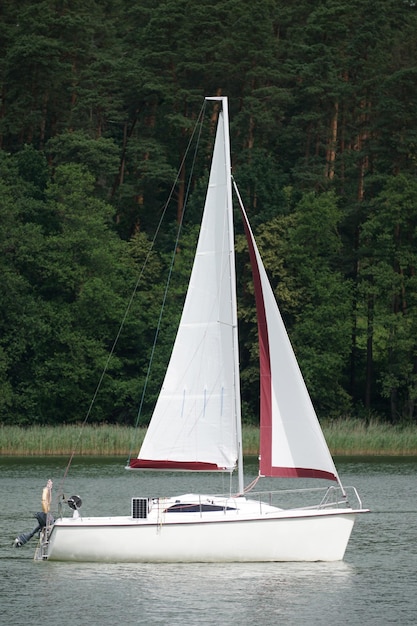 Sailboat swimming on a lake side view