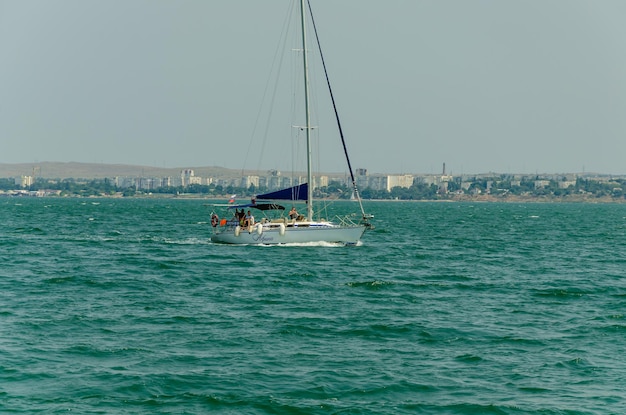 A sailboat with a tall mast is sailing in the water.