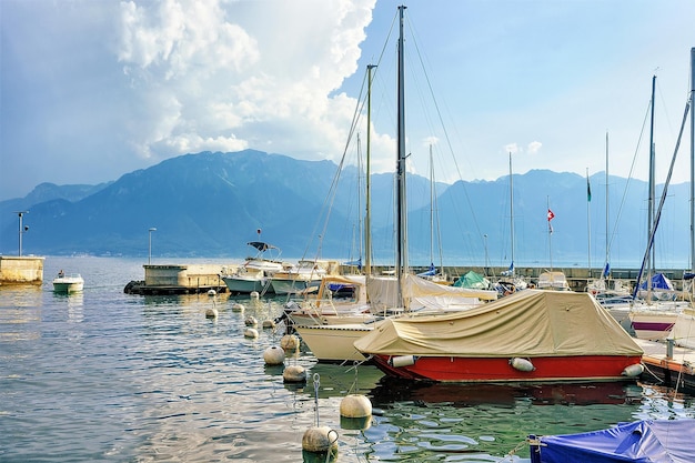 스위스 보(Vaud) 주 브베(Vevey)에 있는 제네바 호수(Geneva Lake)의 정박지에 있는 요트. 배경에 사람들