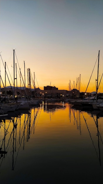 Foto barche a vela nella marina al tramonto