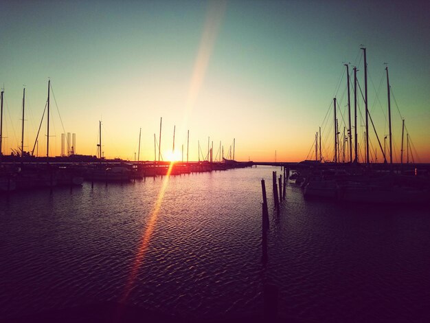 Foto barche a vela nel porto al tramonto