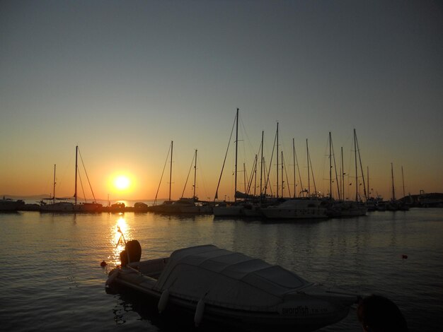 Foto barche a vela nel porto al tramonto