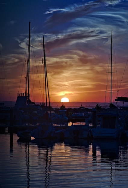 Foto barche a vela nel porto al tramonto