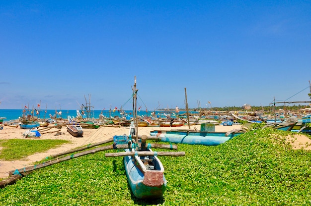 Sailboats moored at harbor against clear blue sky