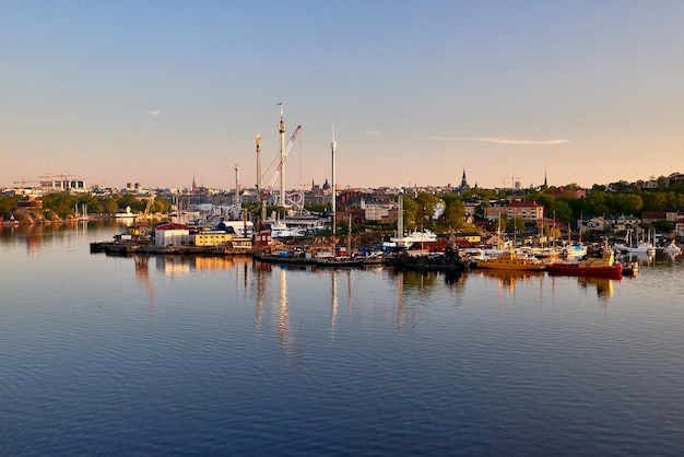 Sailboats moored at harbor against sky during sunset