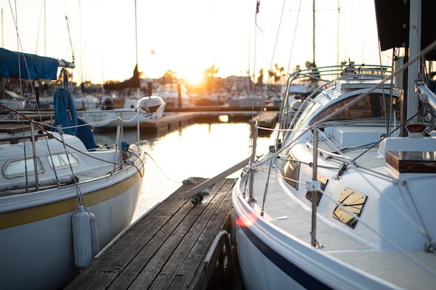 Photo sailboats moored in harbor at sunset