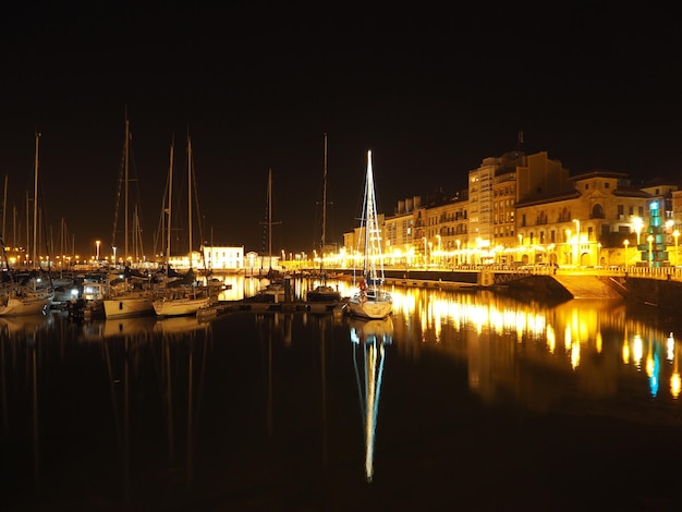 Foto barche a vela ormeggiate nella marina di notte