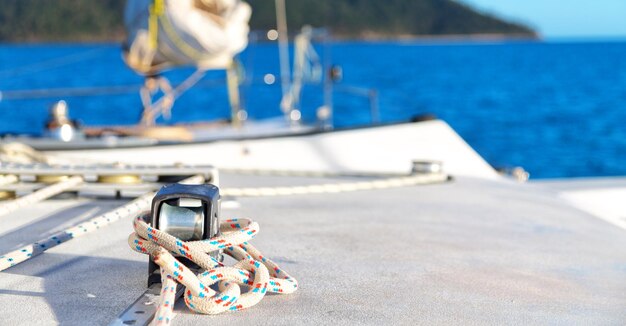 Sailboats moored on pier against sea during sunny day