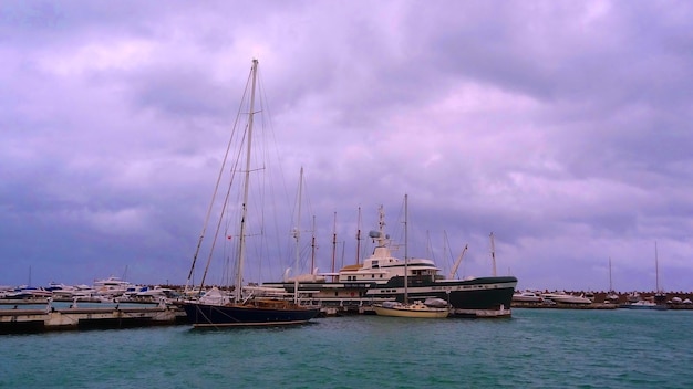 Sailboats moored in sea against sky