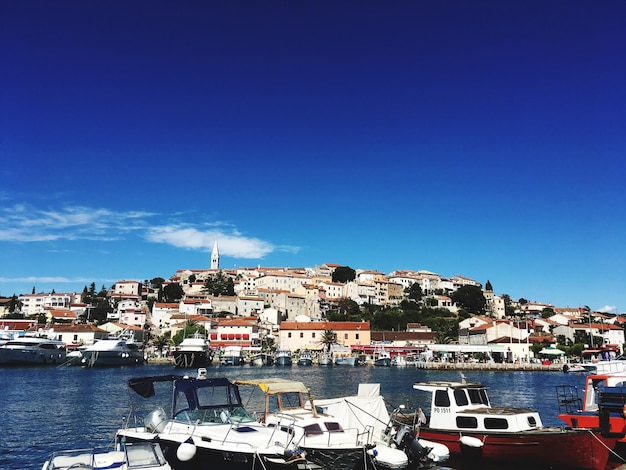 Foto barche a vela ormeggiate sul mare da edifici contro il cielo blu