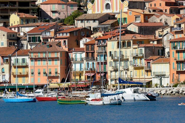 Sailboats moored in town by residential buildings