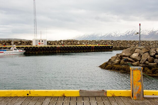 Sailboats on pier by sea against sky