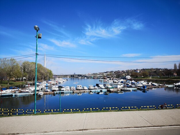 Sailboats in river against blue sky