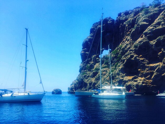 Foto barche a vela che navigano in mare contro un cielo blu limpido