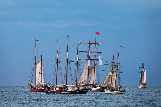 Foto barche a vela che navigano in mare contro il cielo