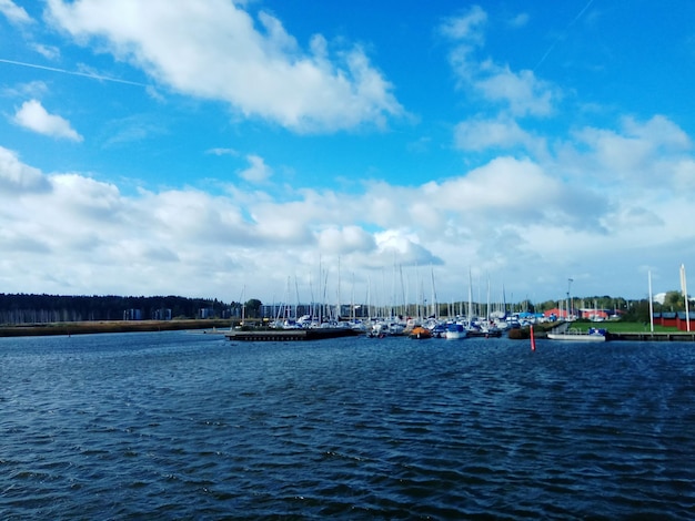 Sailboats in sea against sky