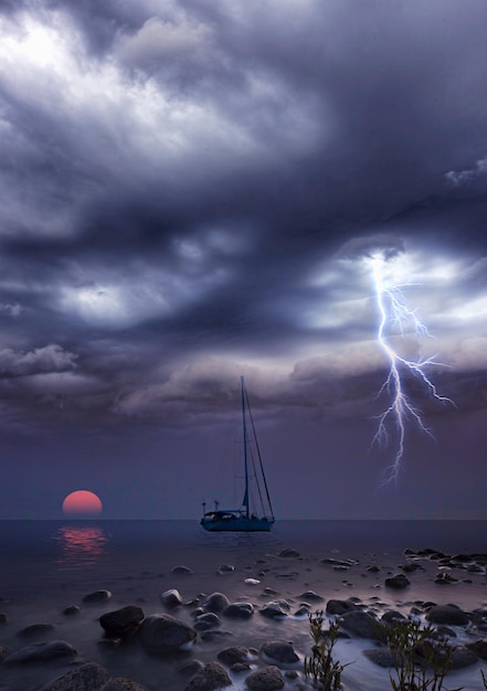 sailboats in sea against storm clouds