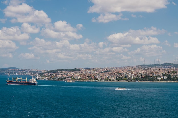 Sailboats in sea by buildings against sky