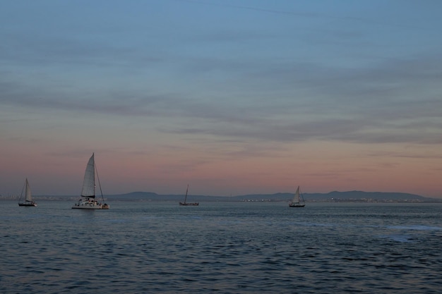 Photo sailboats on a vast sea during sunset