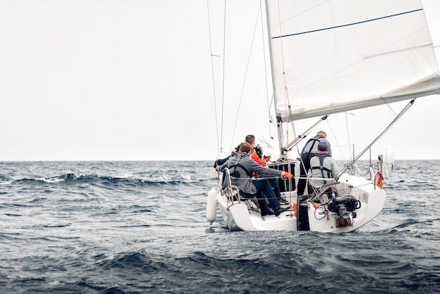 Sailing boat breaking through a stormy sea