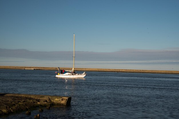 Sailing boat in the sea against the backdrop of mountains