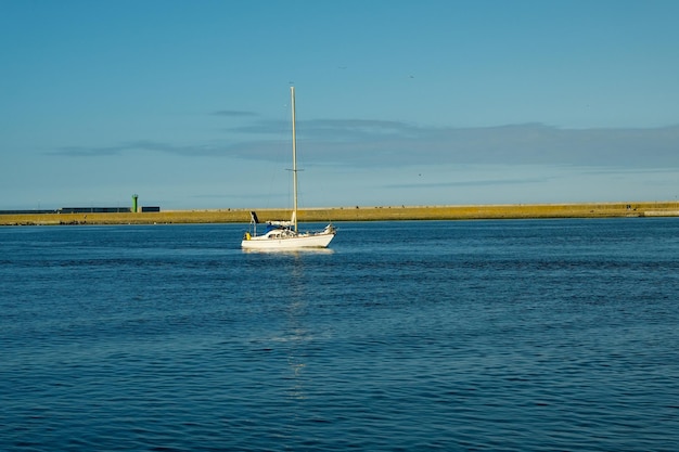 Sailing boat in the sea against the backdrop of mountains